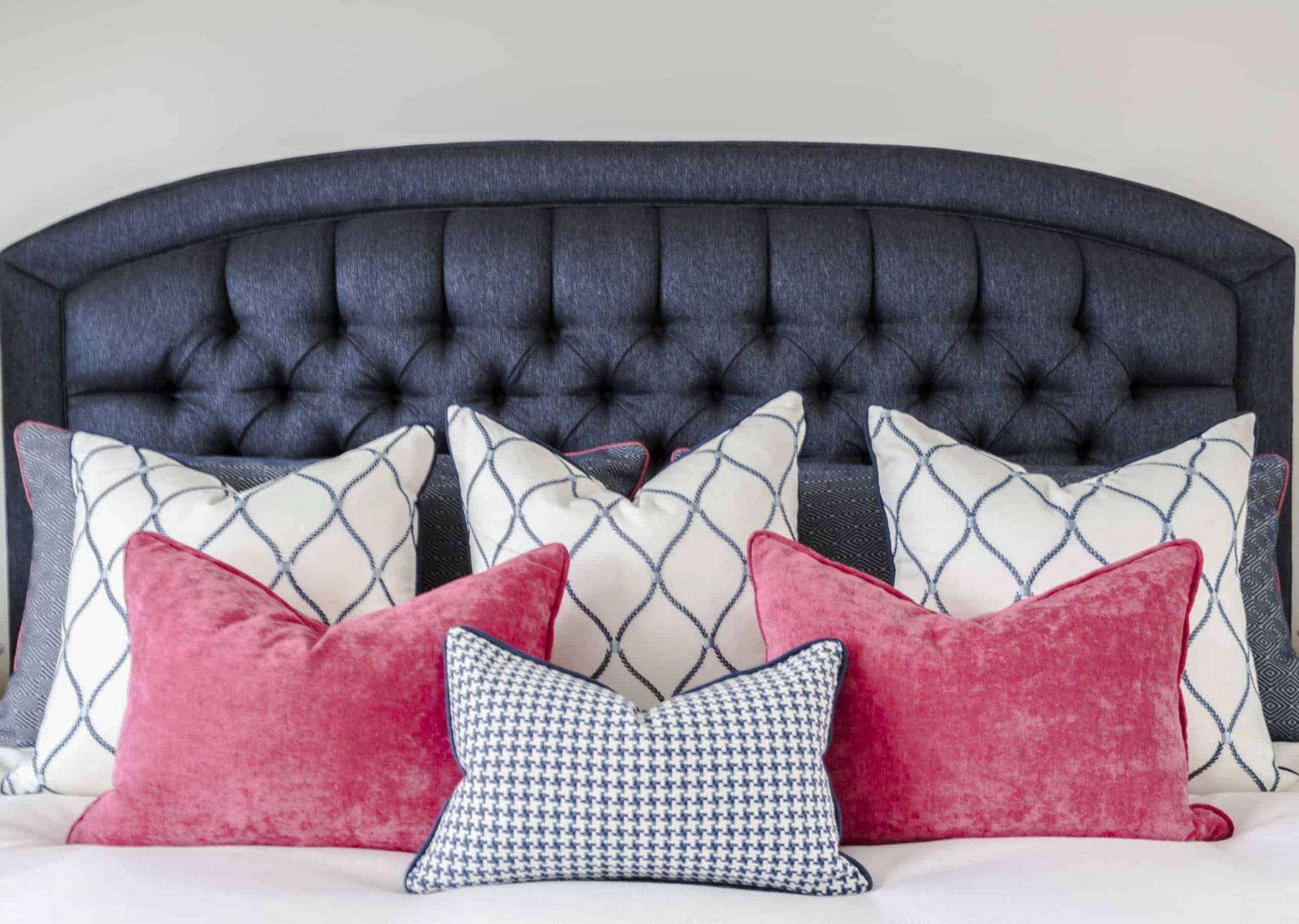 Array of pillows with a blue headboard