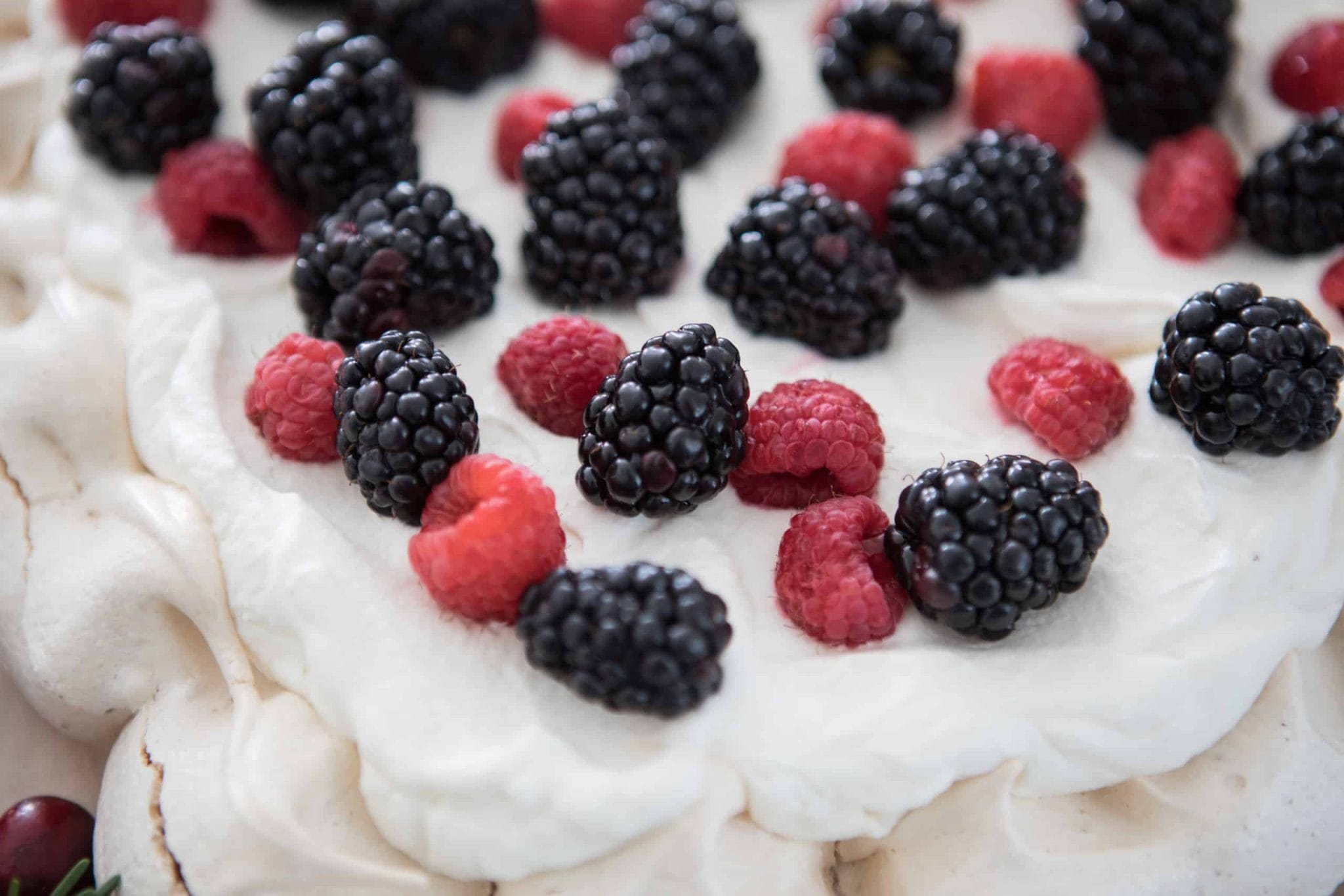 Razzberries and blackberries on a white cake