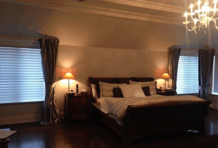 Dark master bedroom with the lamps on